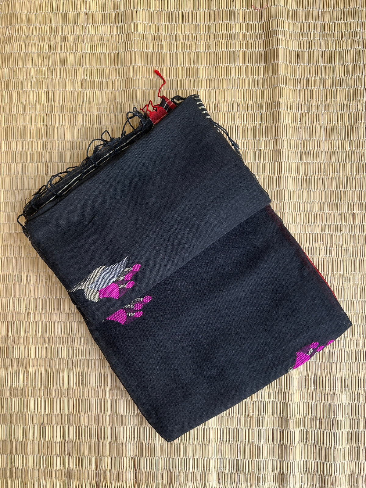 Black linen jamdani saree with floral motifs and orange border