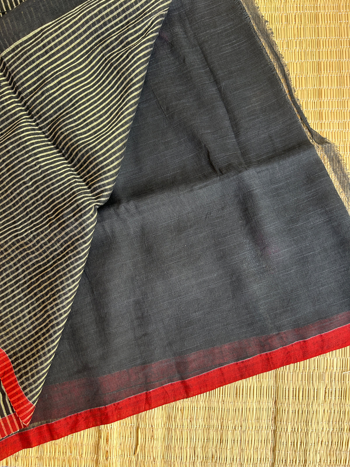 Black linen jamdani saree with floral motifs and orange border